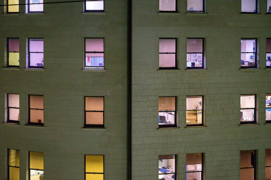 夜のオフィスで自分の評価に不安を感じるビジネスパーソン